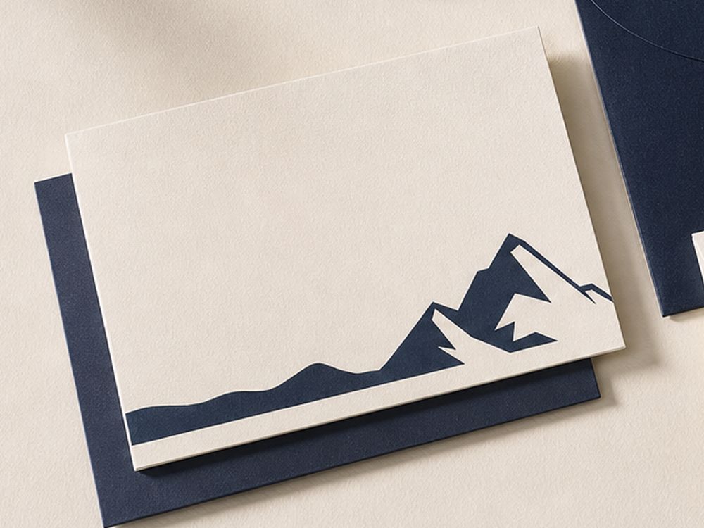 A folded cream Ridgeline greeting card with a navy mountain illustration