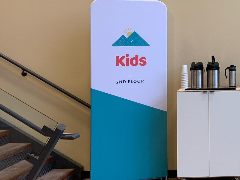 A fabric tension display marking a children’s ministry area in a church hallway